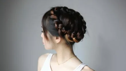 Side view of a girl with intricate crown braid hairstyle for hair braiding Bali service